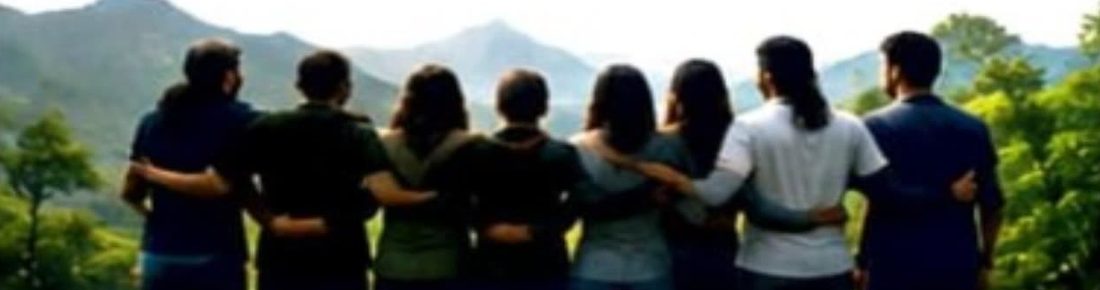 A group of friends standing together, arms around each other, facing mountains